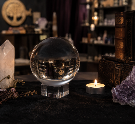 Boule de cristal de divination 100 mm sur support avec ambiance ésotérique et bougie
